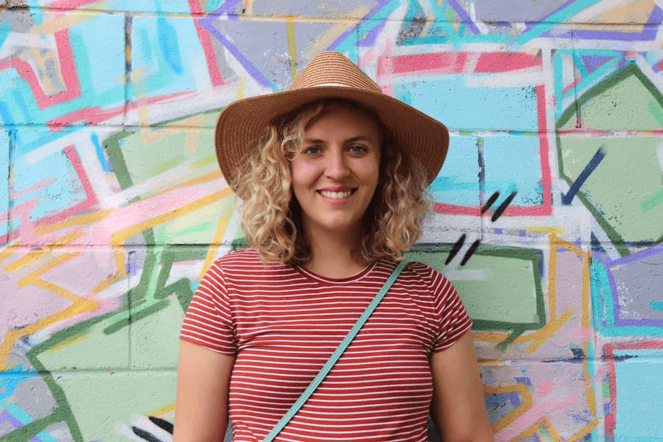 Caitlin Thorne - Young woman with curly blonde hair and red striped shirt holding a ukulele